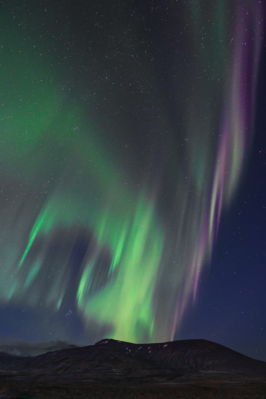 Aurora borealis lights up the night sky with green and purple streaks – just your average Tuesday evening in Iceland.