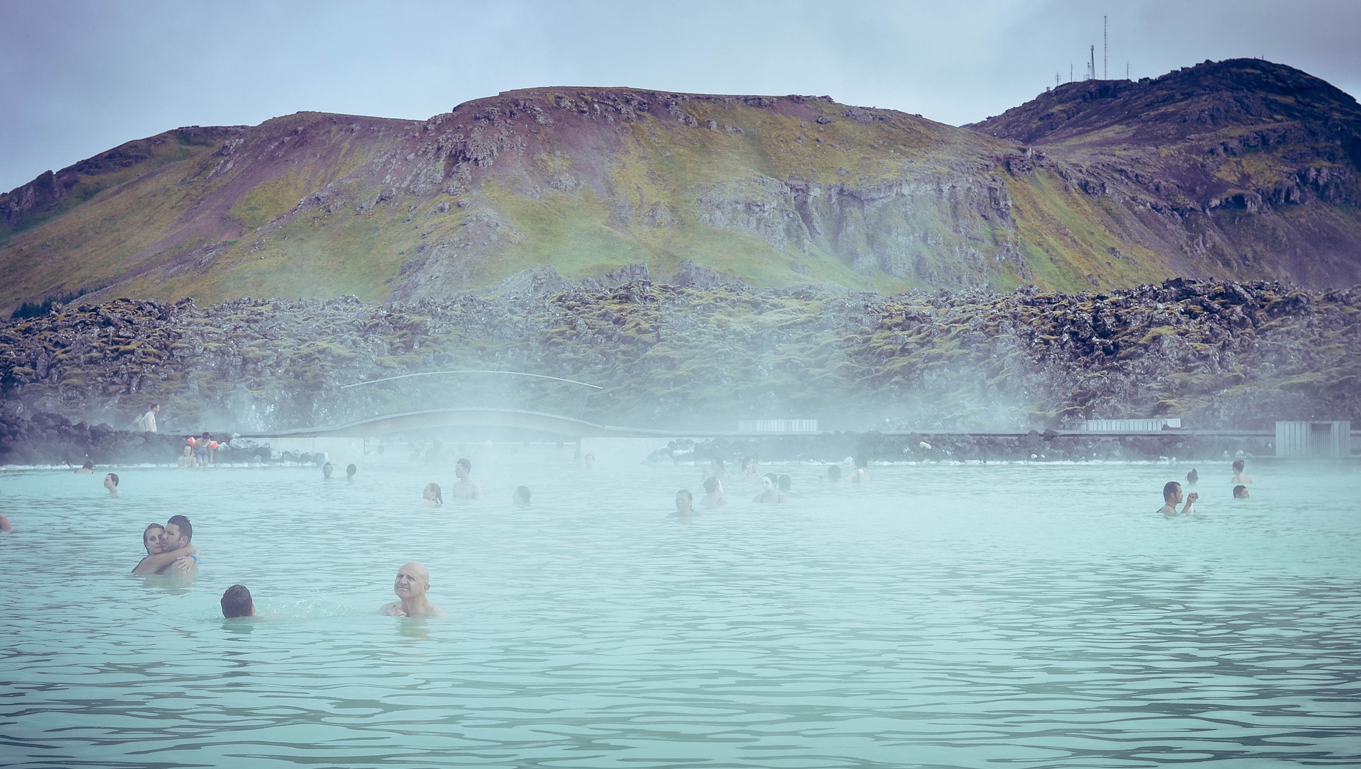 blue lagoon in iceland, steam and people bathing in the hot water