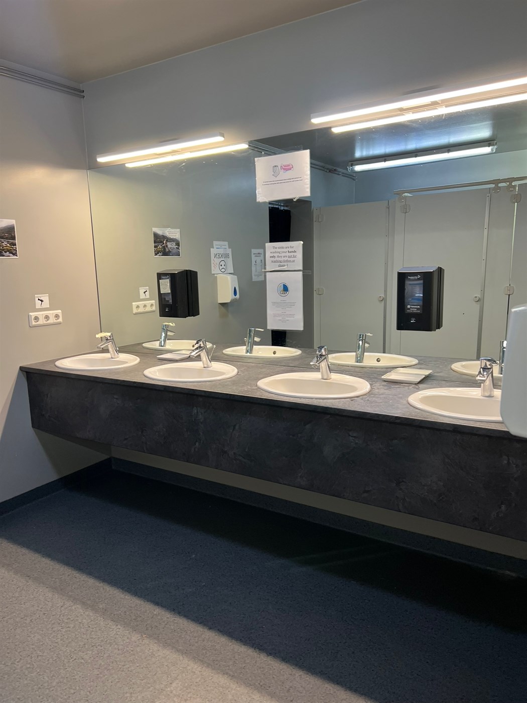 A modern and spotless bathroom area with large mirrors and several sinks at Camp Egilsstaðir – because camping doesn’t mean giving up comfort.