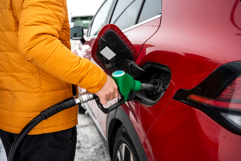 Traveler refueling a car in Iceland before continuing a road trip across the island, a classic stop when driving long distances around the Ring Road.