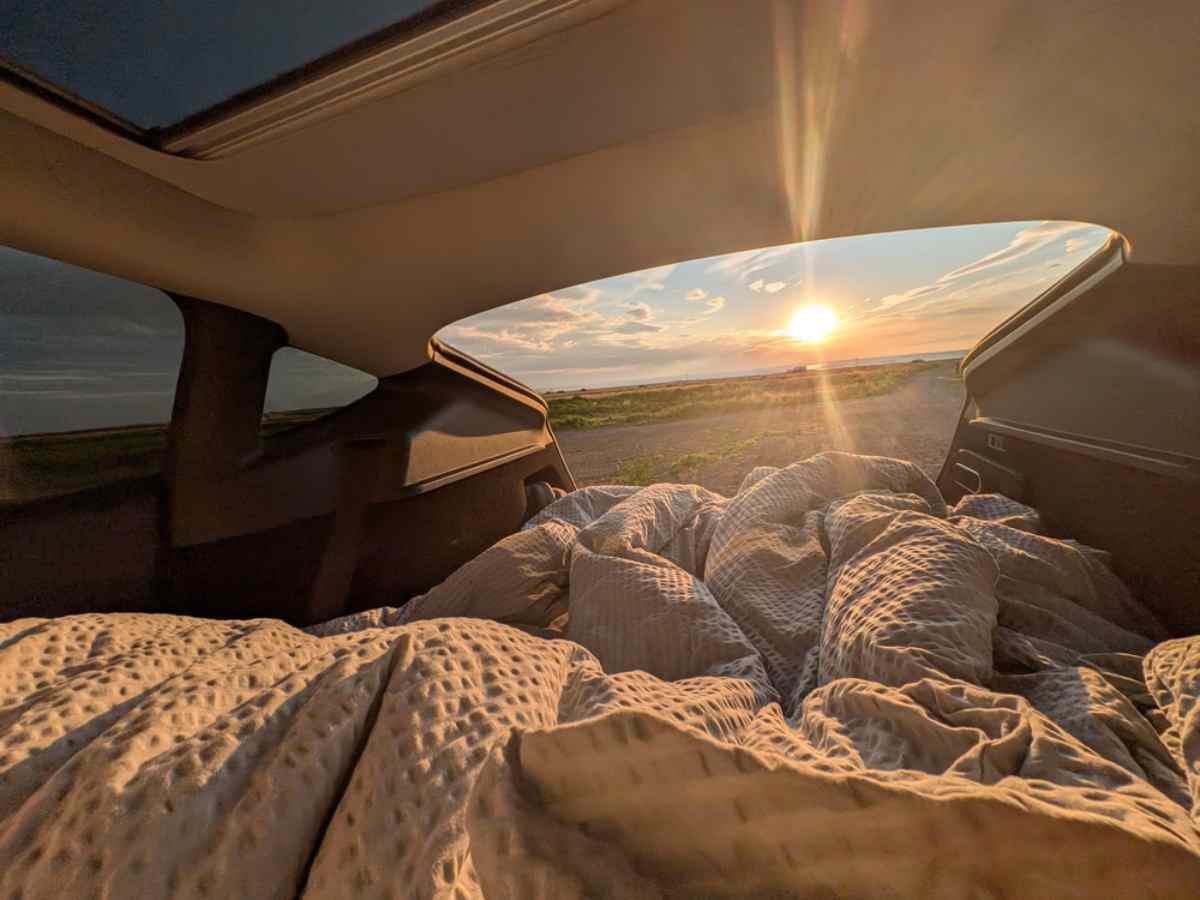 Cozy campervan bed setup during an Iceland road trip Warm bedding inside a campervan in Iceland during sunset on a scenic road trip.
