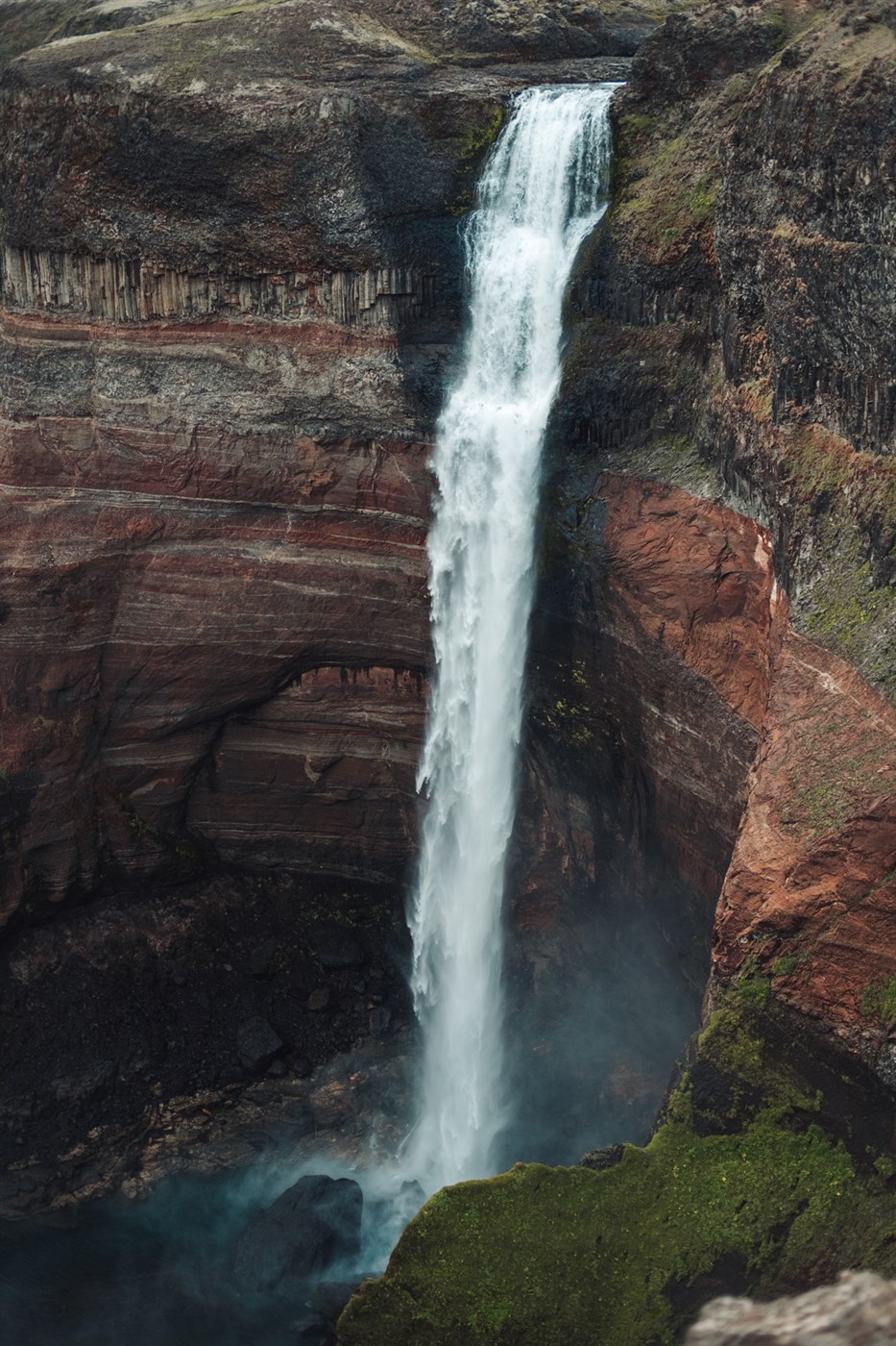 A close-up of Hengifoss, highlighting its cascading waters and the vivid red basalt strata that make this Icelandic waterfall unique