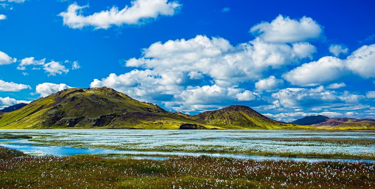 Montagna in Islanda sotto un cielo blu chiaro con alcune nuvole bianche.