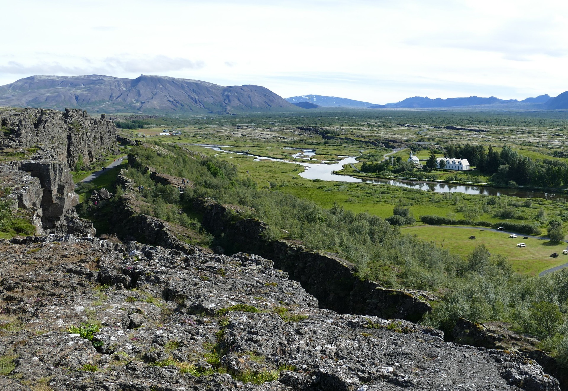 National park of Thingvellir, rocks on the foregroung, grass, tress, mountains on the background