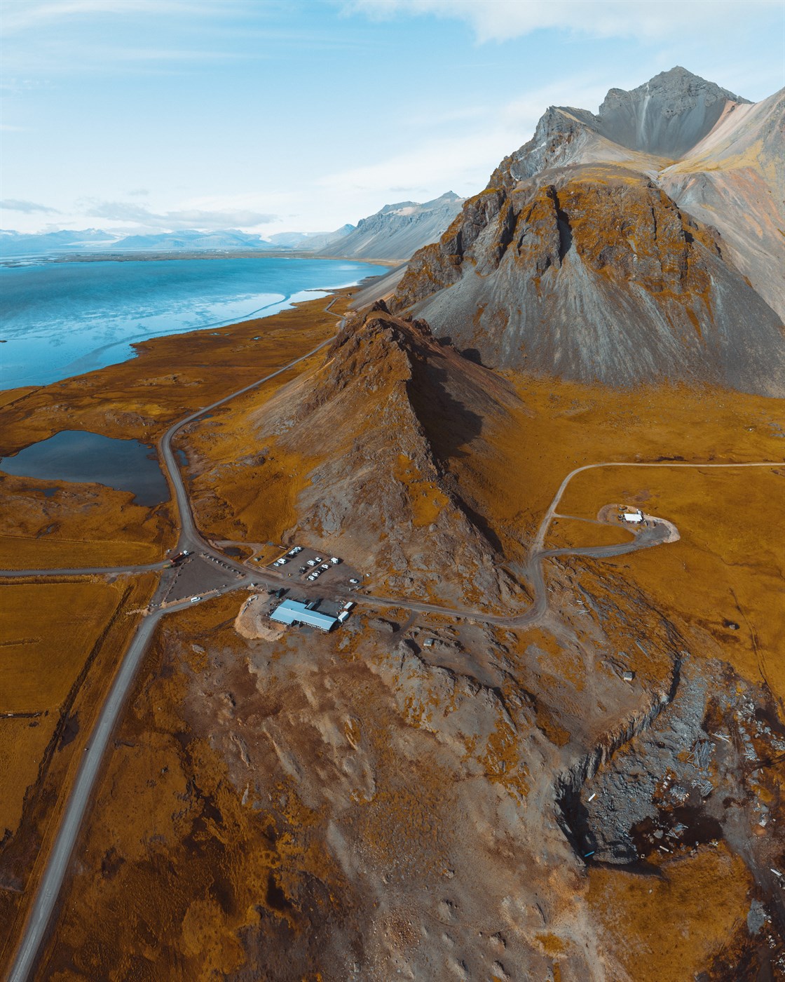 Sweeping drone shot of Vestrahorn and the surrounding area, where ocean meets mountain and every turn looks like a postcard.